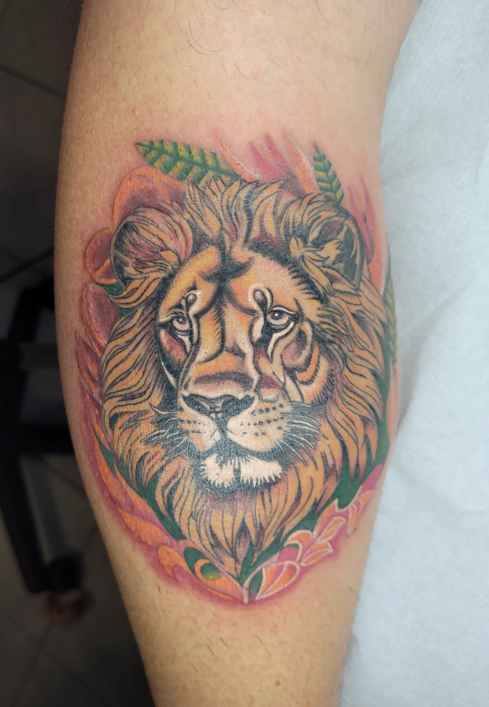 Tatouage couleur d'une tête de lion sur le mollet, réalisé par Jean-Marie Joullié au salon JMJ Tattoo proche de Valras-Plage