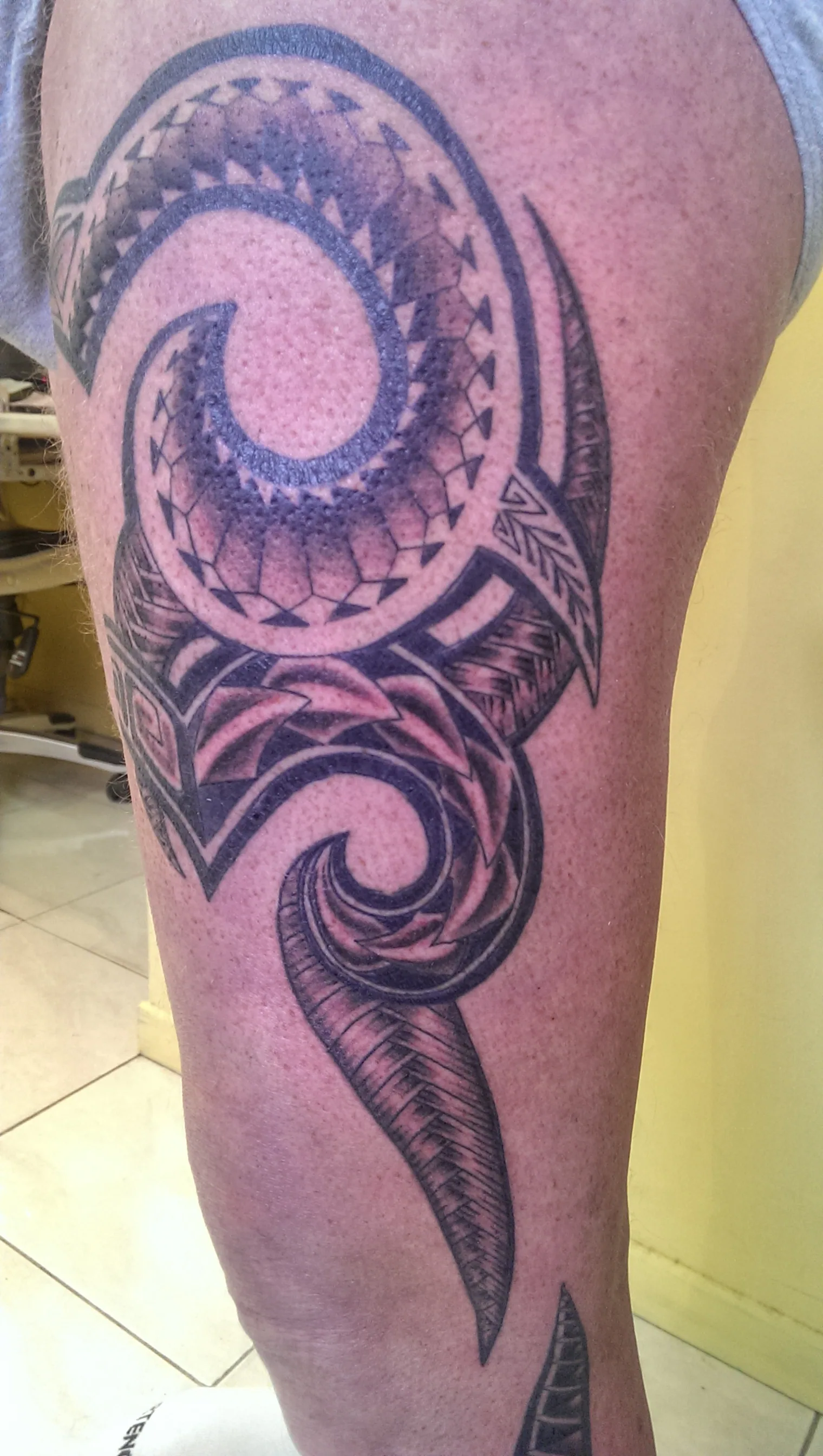 Tatouage tribal polynésien à motifs koru sur la cuisse, réalisé par Jean-Marie Joullié au salon JMJ Tattoo proche d'Agde