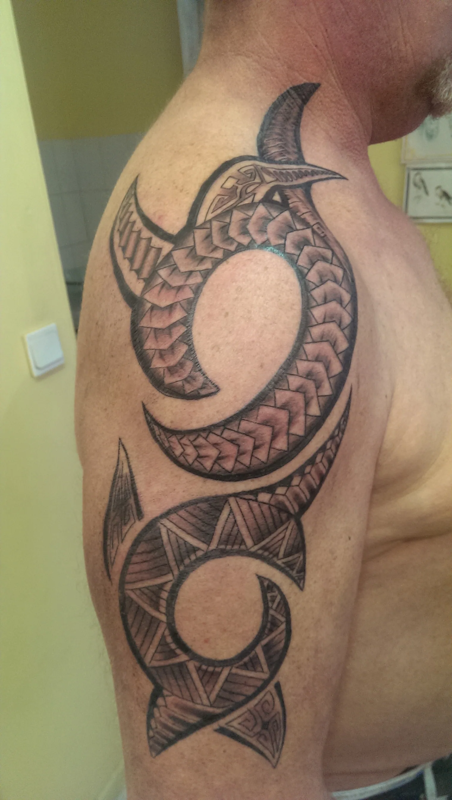 Tatouage tribal polynésien à motifs de spirales sur l'épaule, réalisé par Jean-Marie Joullié au salon JMJ Tattoo à Béziers et Sérignan